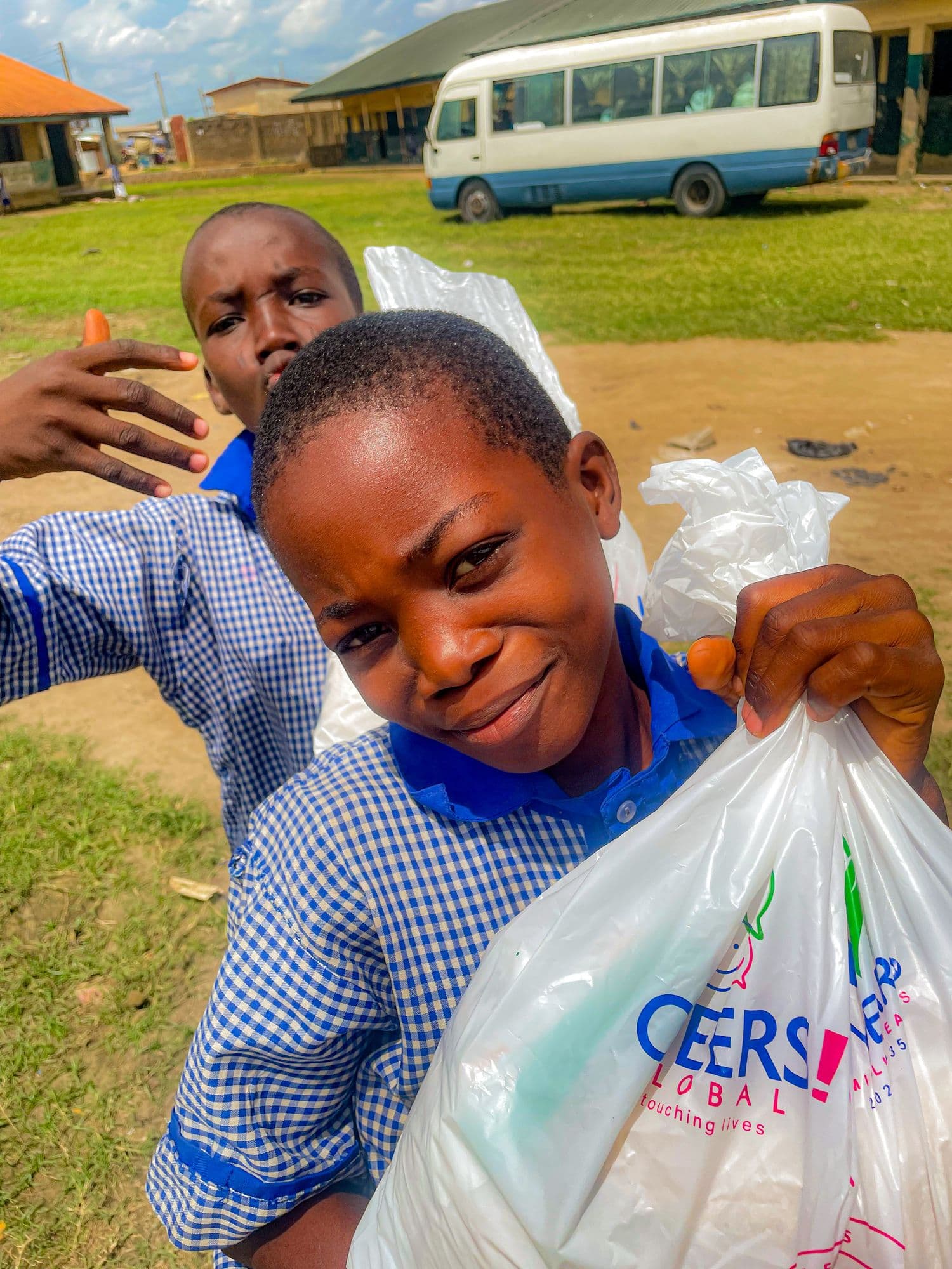 A schoolboy holding up a Cheers Global Back to School bag