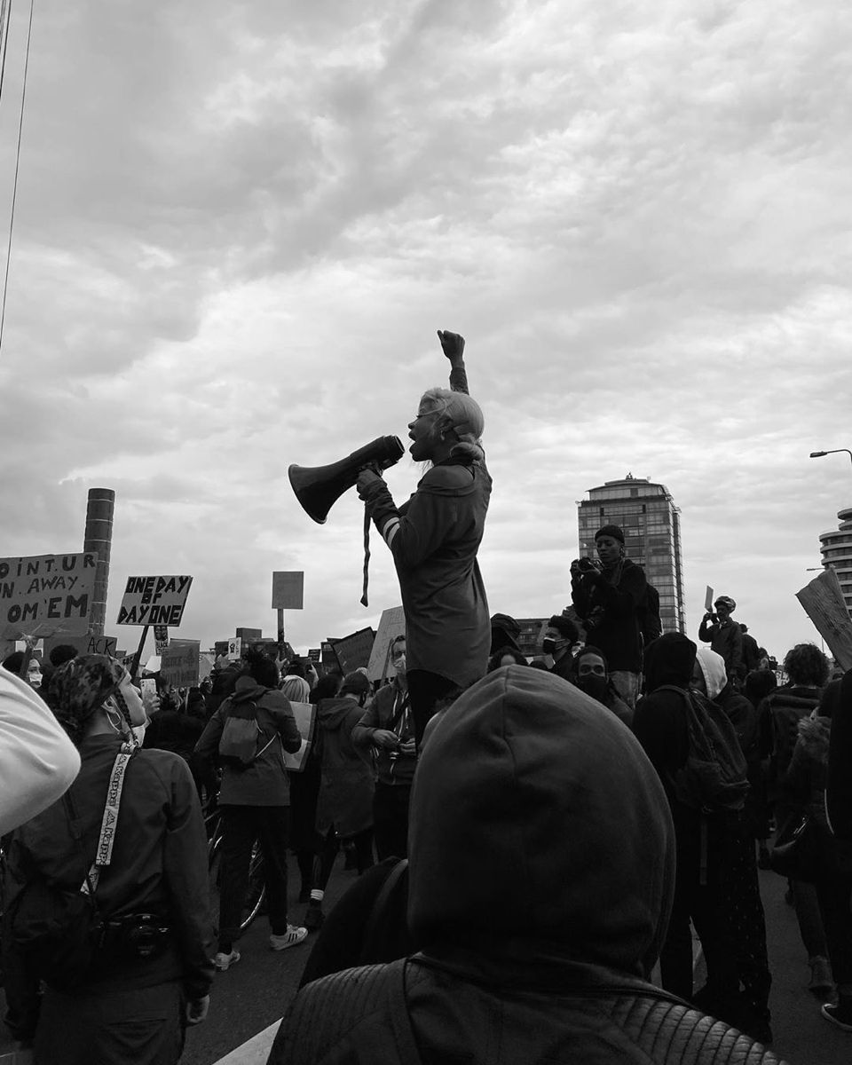 A marcher speaking through a megaphone at A Thousand Man March