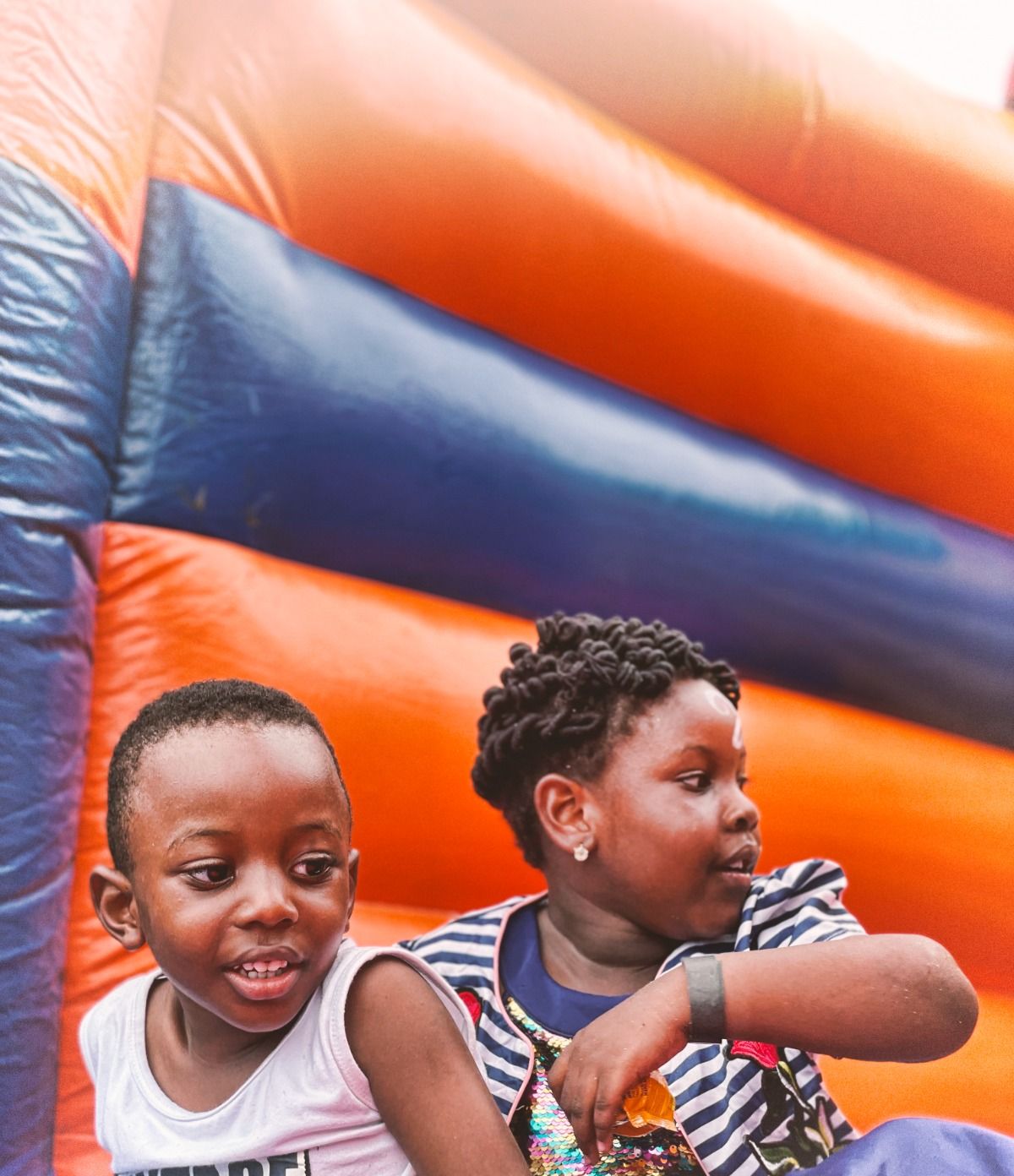 Two children smiling in front of a bouncy castle at the Back to School party