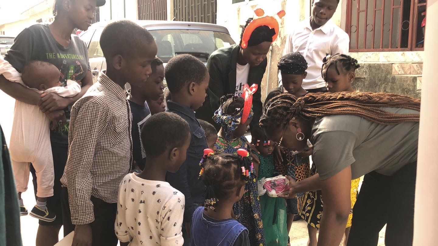 A volunteer handing out shoes to children